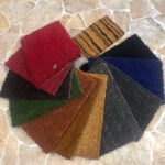 Campione di tappeti per interni in fibra naturale di vari colori tra: cui: rosso, nero, verde, grigio, blu e leopardato