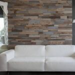 Moquette e Parquet - Parete in legno riciclato boiserie 3.0, situata all'interno di un salotto con un divano bianco