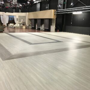 Ampio set di ripresa vuoto in uno studio televisivo, con aree delimitate e illuminazione da palcoscenico.