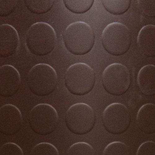 Immagine di una superficie marrone con un motivo circolare in rilievo, che crea un interessante effetto visivo.