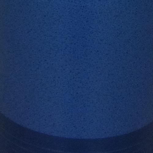 Primo piano di una superficie blu opaca con lievi variazioni nel colore e una texture fine, situata in basso.