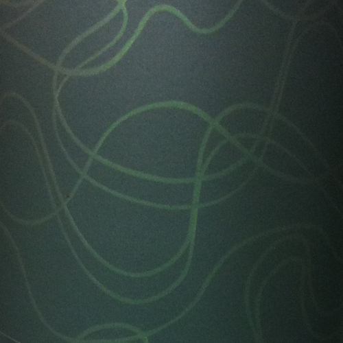 Primo piano di un tessuto verde scuro con motivi ondulati discreti e linee fluide che creano un effetto suggestivo.