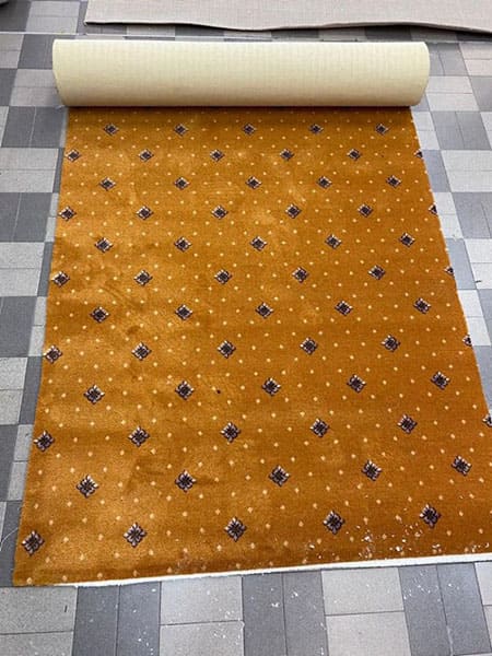 Moquette di colore ocra con i fiori stesa sul pavimento