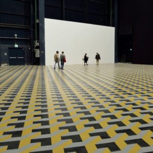 Pavimento in PVC/Linoleum con illusione ottica 3D a tassellazione geometrica, in ampio spazio espositivo.